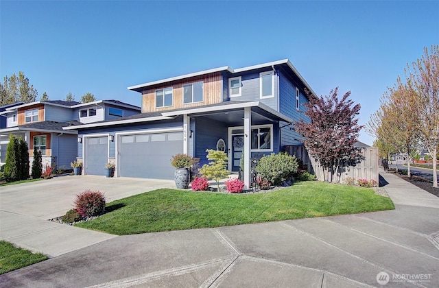 view of front of house with an attached garage, concrete driveway, and a front yard