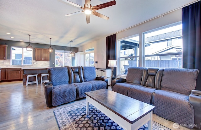 living area featuring ceiling fan, light wood-style flooring, and a wealth of natural light