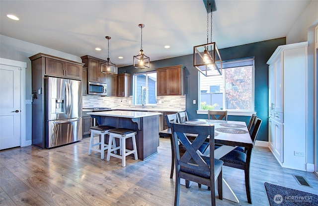 kitchen with plenty of natural light, light countertops, appliances with stainless steel finishes, and a kitchen island