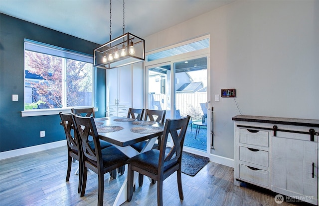 dining area with baseboards and wood finished floors
