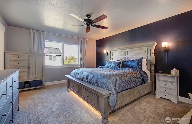 carpeted bedroom with baseboards, ceiling fan, and a textured ceiling