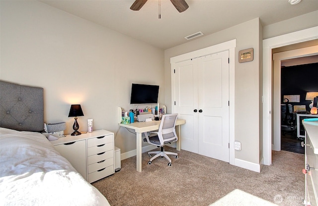 bedroom with visible vents, a closet, baseboards, ceiling fan, and light colored carpet