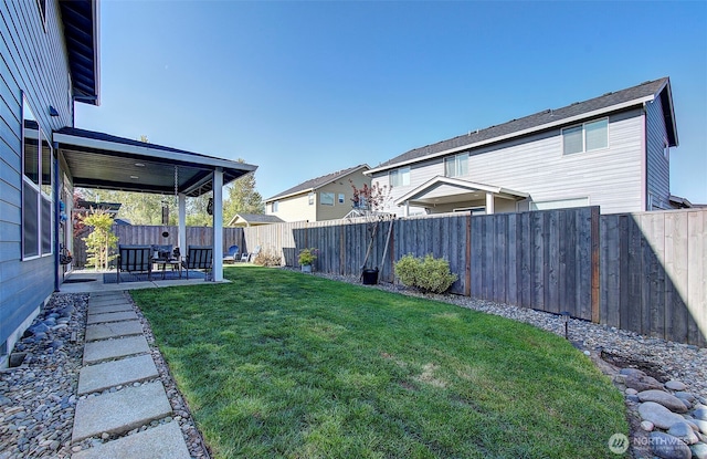 view of yard featuring a fenced backyard, a patio area, and a residential view