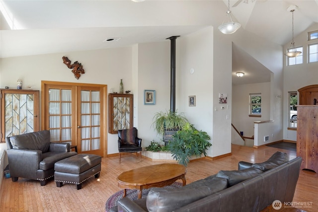 142 Pemberton Pl, Friday Harbor, WA 98250 - living room with a wood stove, high vaulted ceiling, visible vents, baseboards, and wood finished floors