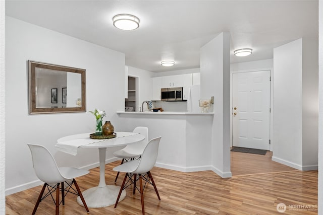 dining room with light wood-style floors and baseboards