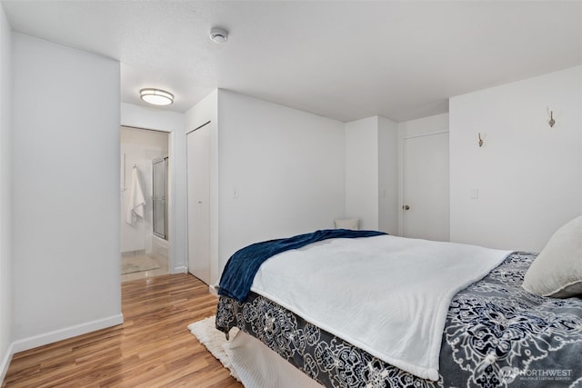 bedroom featuring a closet, baseboards, and wood finished floors