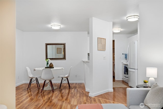 dining room with light wood-type flooring and baseboards