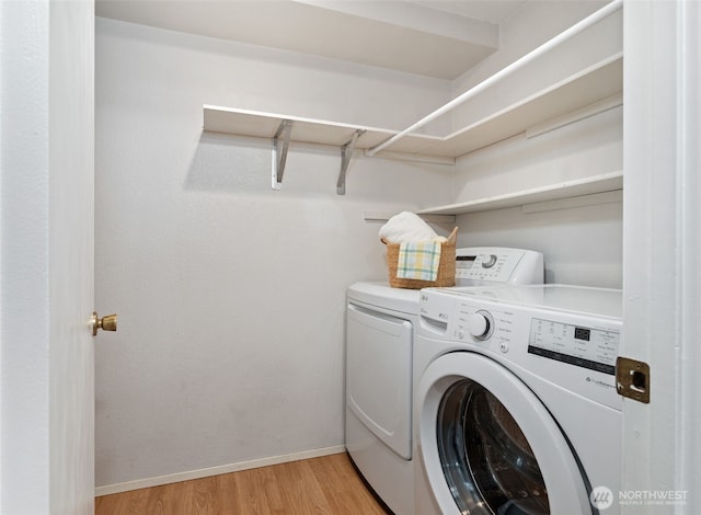 laundry room with washer and dryer, laundry area, light wood finished floors, and baseboards