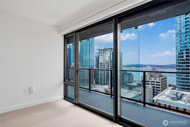 300 Virginia St Unit 1710, Seattle, WA 98101 - spare room with a city view, plenty of natural light, and wood finished floors