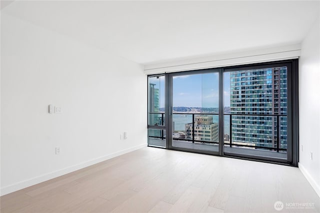 300 Virginia St Unit 1710, Seattle, WA 98101 - spare room featuring wood finished floors, a view of city, and baseboards