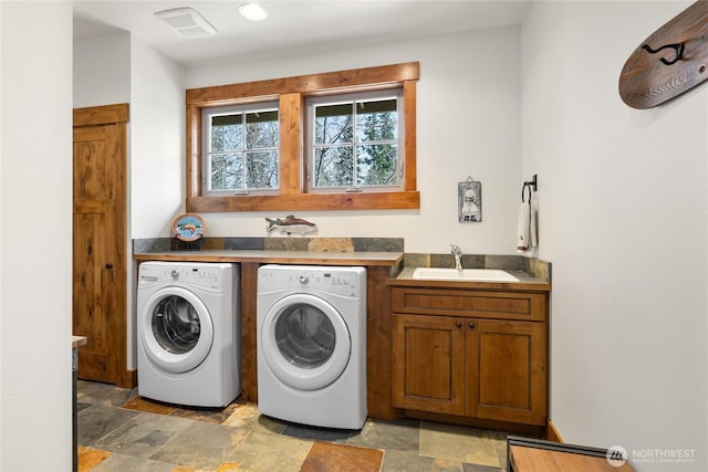 111 Cake Box Ln, Cle Elum, WA 98922 - laundry area with stone finish flooring, washing machine and clothes dryer, cabinet space, and a sink