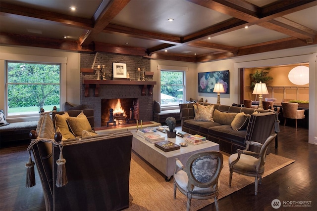 living area with wood finished floors, coffered ceiling, a brick fireplace, and beam ceiling