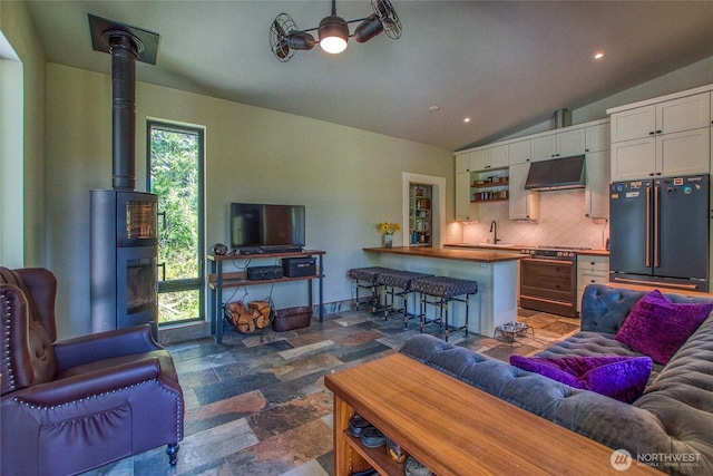 living area featuring recessed lighting, vaulted ceiling, and stone finish flooring