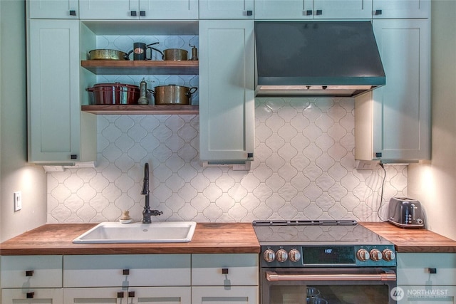 kitchen with decorative backsplash, a sink, butcher block countertops, stainless steel electric range, and range hood