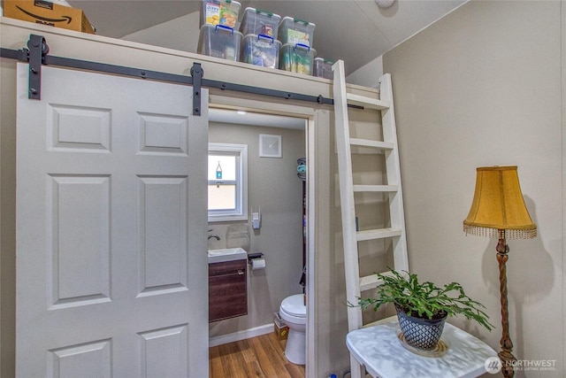 bathroom featuring wood finished floors, toilet, and vaulted ceiling