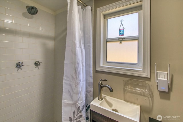 bathroom with a tile shower and vanity