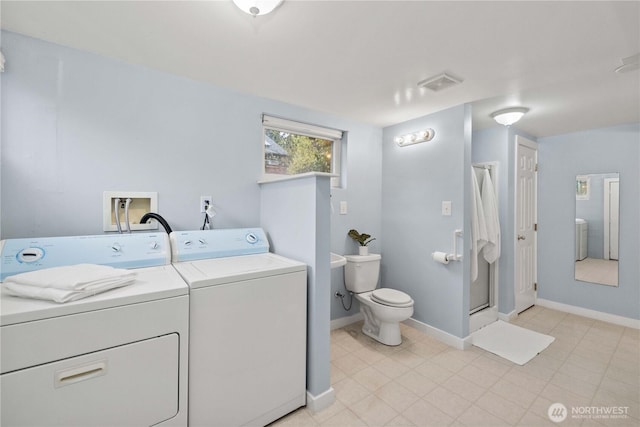 washroom featuring washing machine and dryer, visible vents, baseboards, and laundry area