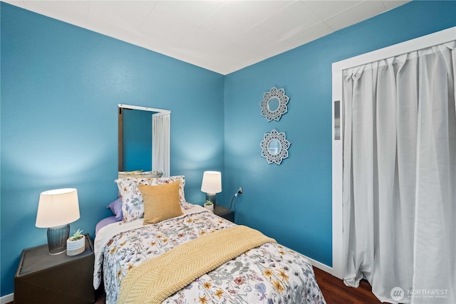 bedroom with baseboards and wood finished floors