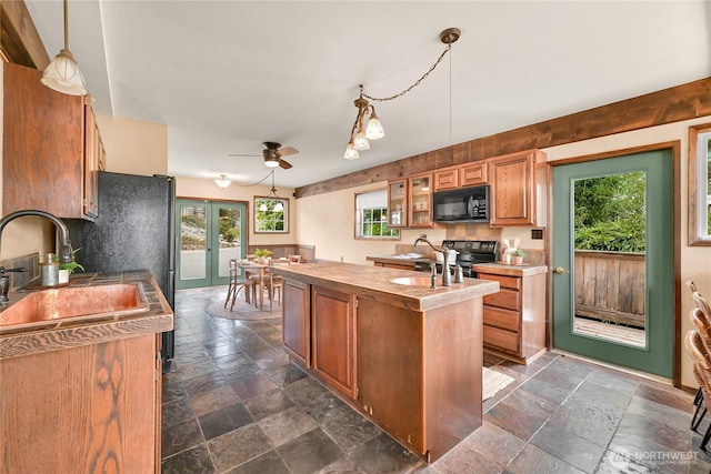 1016 Coronado Ave, Bellingham, WA 98229 - kitchen featuring black appliances, stone tile floors, a kitchen island, and a sink