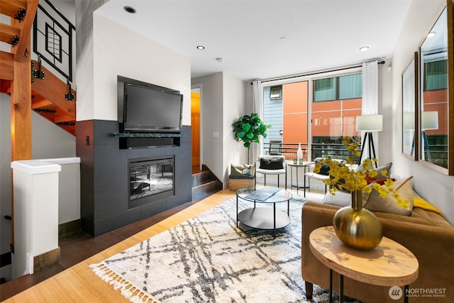 living area featuring a multi sided fireplace and wood finished floors