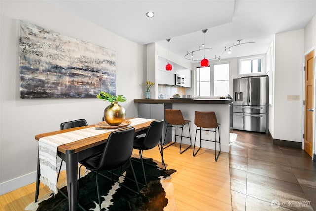 dining area with track lighting, baseboards, light wood finished floors, and recessed lighting