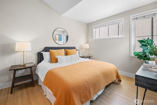 bedroom featuring baseboards, vaulted ceiling, and wood finished floors