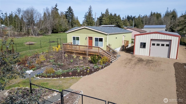 view of front of home with an outdoor structure, driveway, a front yard, a garage, and fence