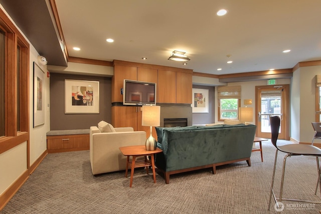 living room featuring baseboards, a fireplace, recessed lighting, and light colored carpet