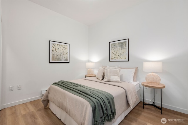 bedroom with baseboards and wood finished floors