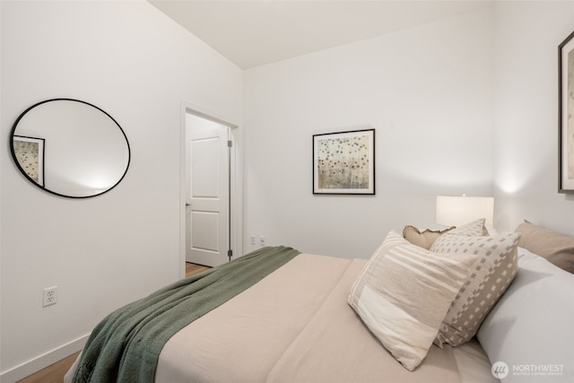 bedroom with baseboards and wood finished floors
