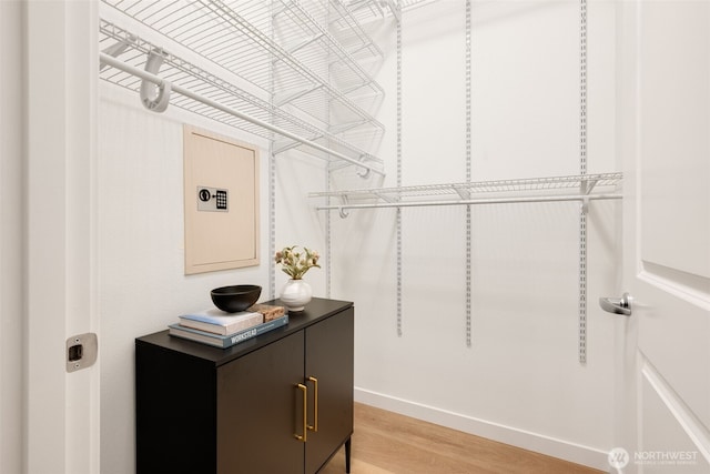 walk in closet featuring light wood finished floors and electric panel
