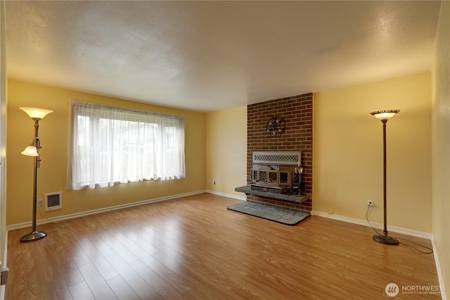 unfurnished living room featuring wood finished floors and baseboards