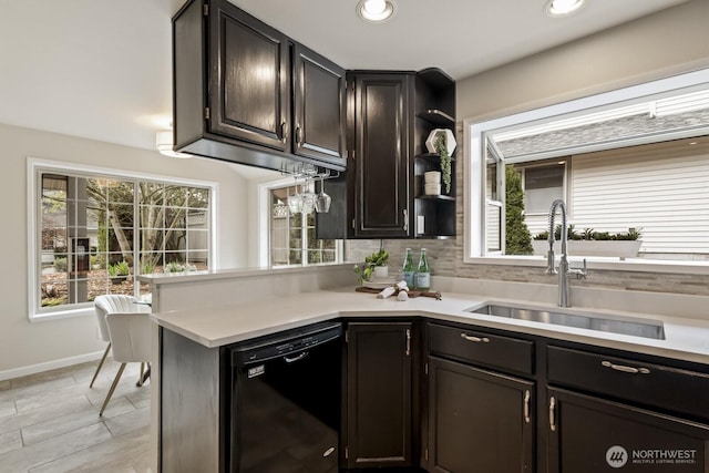 kitchen featuring light countertops, a healthy amount of sunlight, dishwasher, and a sink
