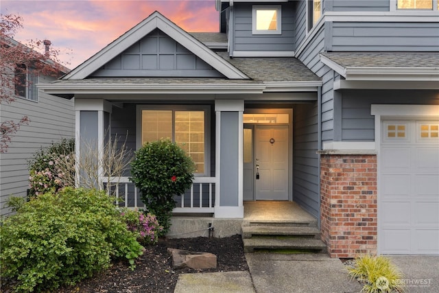 exterior entry at dusk with brick siding and roof with shingles