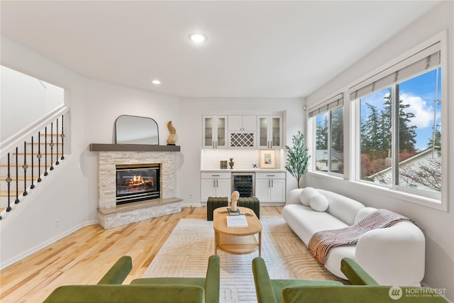living room featuring a dry bar, light wood-type flooring, recessed lighting, stairway, and beverage cooler