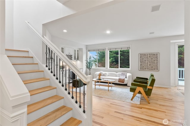 stairs featuring recessed lighting, visible vents, baseboards, and wood finished floors