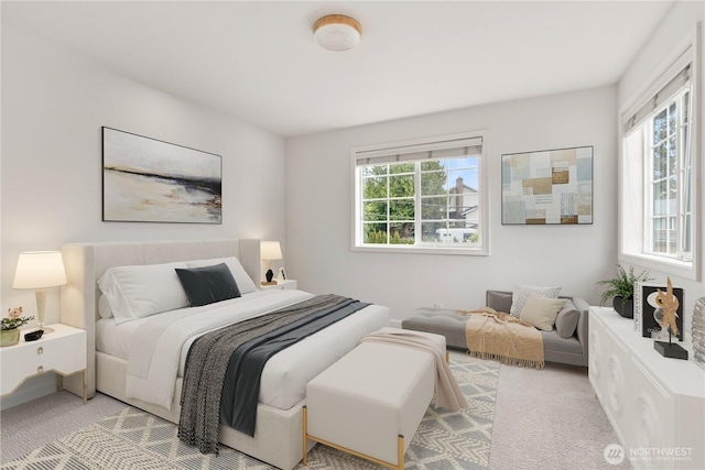 bedroom featuring light carpet and multiple windows