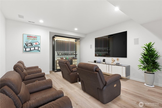 living room with light wood-type flooring, visible vents, recessed lighting, a bar, and baseboards