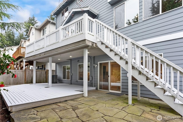 exterior space with stairs, a deck, and fence