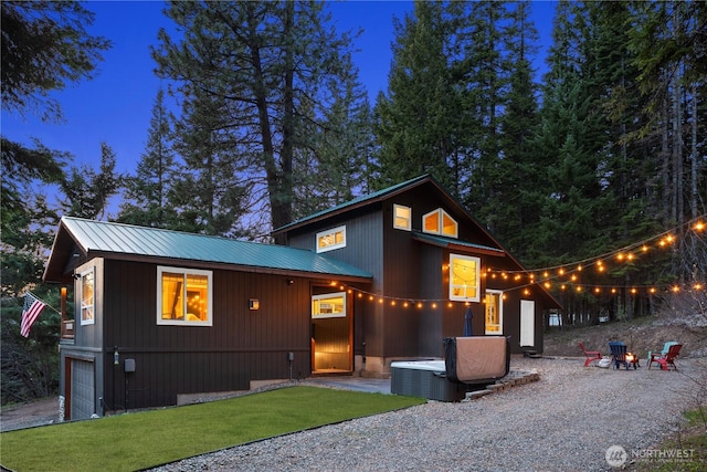 modern home featuring a garage, driveway, a front yard, and metal roof
