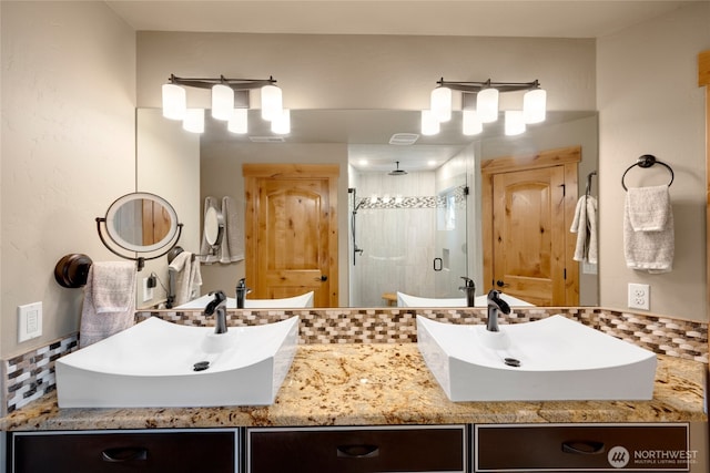 bathroom featuring a stall shower and double vanity
