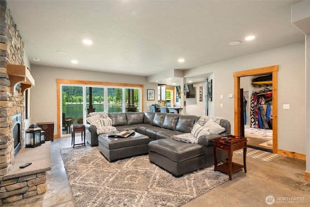 living room with finished concrete flooring, recessed lighting, and a fireplace