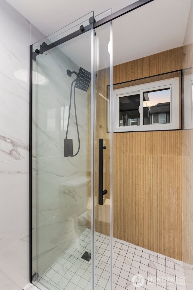 bathroom featuring wooden walls and a shower stall