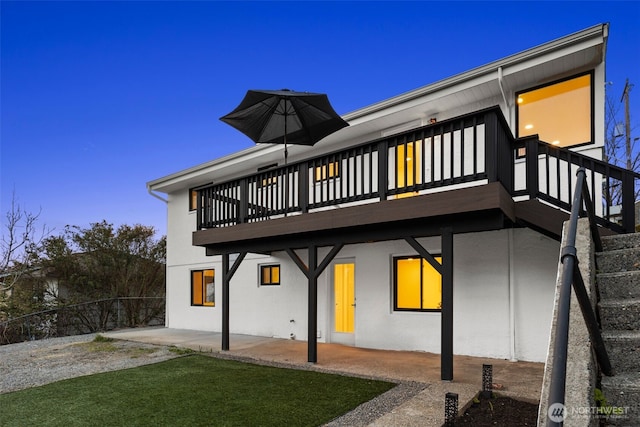 back of house with fence, a patio area, and stucco siding