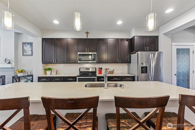 19225 Damson Rd Unit J2, Lynnwood, WA 98036 - kitchen with pendant lighting, a breakfast bar, a sink, and stainless steel appliances
