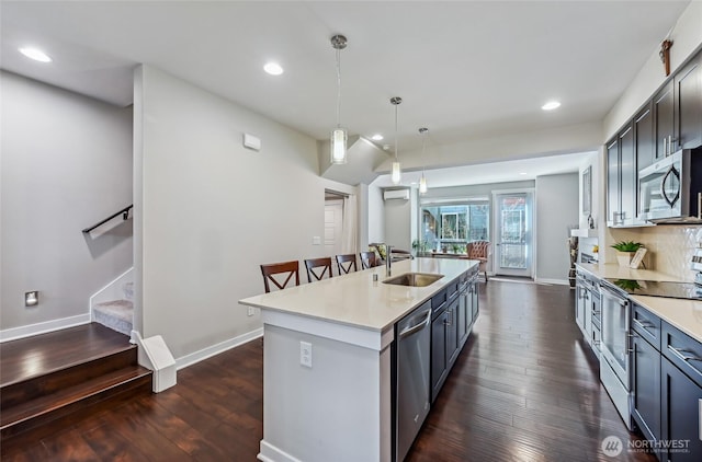 19225 Damson Rd Unit J2, Lynnwood, WA 98036 - kitchen featuring dark wood-type flooring, a center island with sink, a sink, and appliances with stainless steel finishes