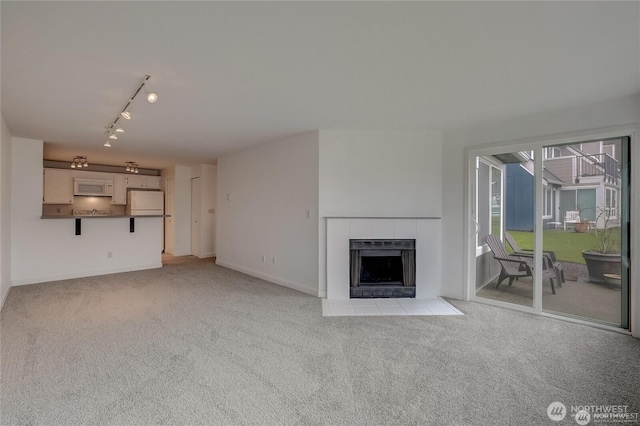 24762 45th Ave S Unit 12-D1, Kent, WA 98032 - unfurnished living room with carpet flooring, a tile fireplace, baseboards, and track lighting