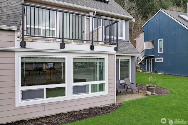 24762 45th Ave S Unit 12-D1, Kent, WA 98032 - back of house with a balcony, a shingled roof, and a lawn