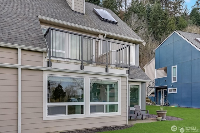 24762 45th Ave S Unit 12-D1, Kent, WA 98032 - back of house with a balcony, roof with shingles, and a lawn