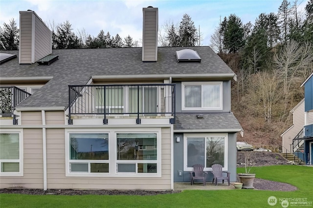 24762 45th Ave S Unit 12-D1, Kent, WA 98032 - back of property with a balcony, a chimney, roof with shingles, and a lawn